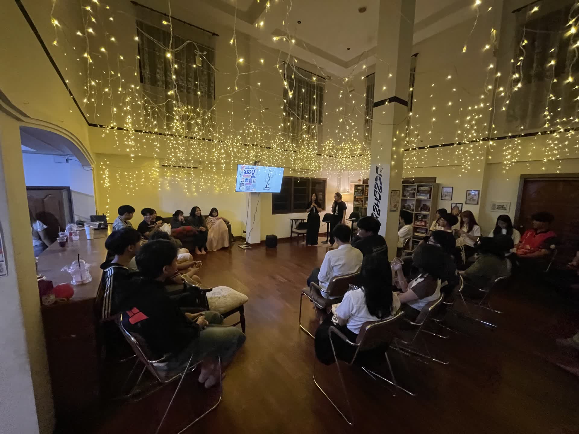 Students gathered in a circle under the fairy lights on a Friday night at The Landing, listening to the message